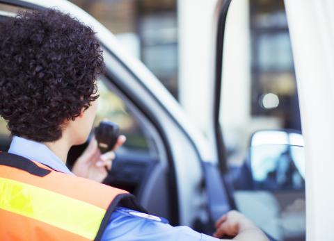 Emergency medical services personnel speaking into radio.